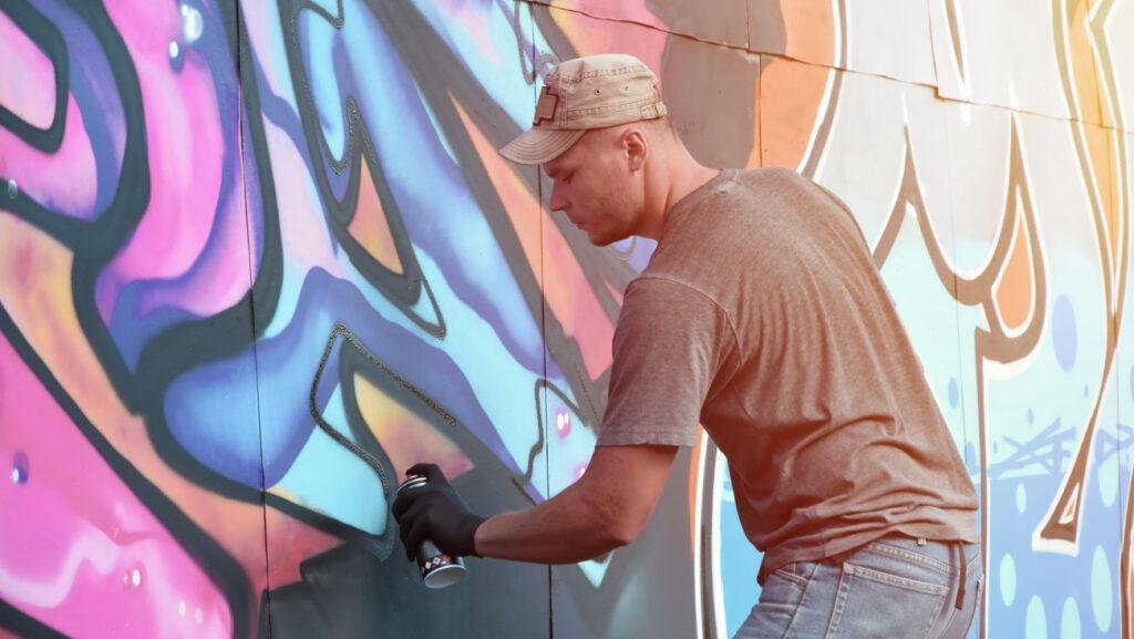 Jeune homme créant un graffiti